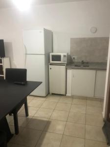 a kitchen with a white refrigerator and a microwave at Remedios de escalada Suite! Wifi Aire cable in Villa María