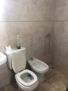 a bathroom with a white toilet and a sink at Remedios de escalada Suite! Wifi Aire cable in Villa María +12 photos