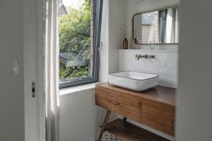 une salle de bain avec un lavabo et une fenêtre dans l'établissement Le Citron, à Veules-les-Roses 22 autres photos