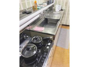 una cucina con piano cottura e pentole. di Guest House Nusa - Vacation STAY 12652 a Kushiro
