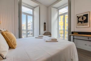 Ando Living - Abrantes Flats في لشبونة: غرفة نوم بيضاء مع سرير كبير مع نوافذ