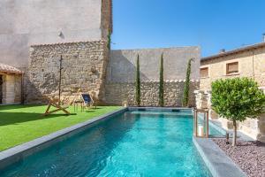 een zwembad in een tuin naast een gebouw bij Palacio Condes de Cirac in Villalba de Rioja