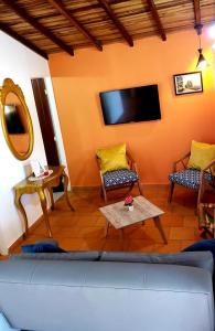 uma sala de estar com um sofá e uma televisão de ecrã plano em GREEN HOUSE CASA O APARTAMENTO CAMPESTRE em San Gil