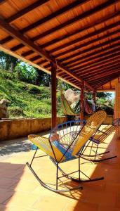 dwa krzesła siedzące na ganku z dachem w obiekcie GREEN HOUSE CASA O APARTAMENTO CAMPESTRE w mieście San Gil