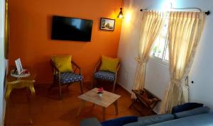 uma sala de estar com duas cadeiras e uma televisão em GREEN HOUSE CASA O APARTAMENTO CAMPESTRE em San Gil