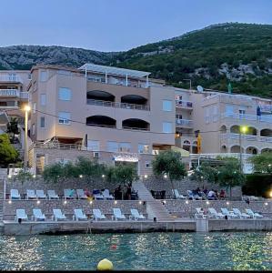 ein großes Gebäude neben einem Wasserkörper in der Unterkunft Villa Domane Mario in Neum