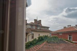 Aussicht aus einem Fenster eines Gebäudes mit Dächern in der Unterkunft The Embassy Suites in Sofia
