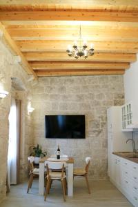 een woonkamer met een tafel en een tv aan een stenen muur bij Sessa's Palace in Korčula