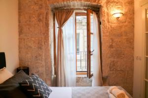 a bedroom with a bed and a window at Sessa's Palace in Korčula