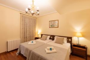 a bedroom with two beds with towels on them at Plaza berri - baskeyrentals in Azpeitia