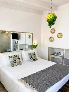una camera con letto bianco e lampadario pendente di In centro unique rooms a Olbia