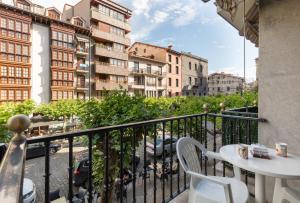a balcony with a table and chairs and buildings at Plaza berri - baskeyrentals in Azpeitia