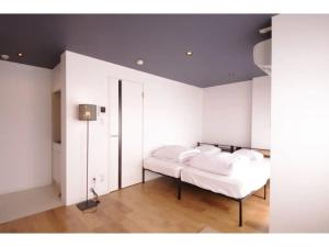 1 dormitorio con paredes blancas y 1 cama con almohadas blancas en HOTEL APT SESELA - Vacation STAY 12880 en Kanazawa