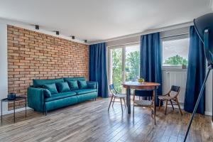 a living room with a blue couch and a table at Apartament Wschodni in Supraśl