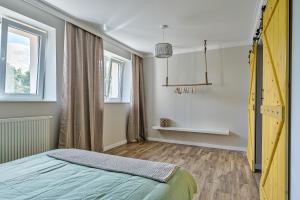 a bedroom with a yellow bed and a window at Apartament Wschodni in Supraśl