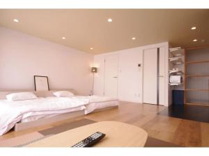 a bedroom with a bed and a remote control on a table at HOTEL APT SESELA - Vacation STAY 12883 in Kanazawa