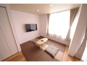 uma pequena sala de estar com uma mesa e uma televisão em HOTEL APT SESELA - Vacation STAY 12883 em Kanazawa