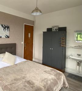 - une chambre avec un lit, une armoire et un lavabo dans l'établissement LA MAISON DE BARLEST - LOURDES, à Barlest