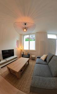 een woonkamer met een bank en een salontafel bij L'Air de la Mer, 2 chambres, 50m plage, parking in Houlgate