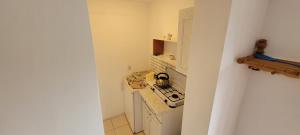 a small kitchen with a tea kettle on a stove at Dom Bursztynek - domek (sad) in Junoszyno