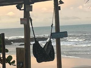 una bolsa colgando de dos postes en la playa en Camping Gnomo Místico, en Olivença