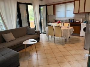 ニドリにあるEmelia Apartmentsのリビングルーム(ソファ、テーブル、椅子付)