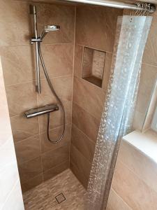 a shower with a shower head and a glass door at Karowlina Cozy House Berlin 1-4 Person in Berlin +23 photos