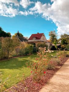 a house with a garden with flowers in the yard at Karowlina Cozy House Berlin 1-4 Person in Berlin