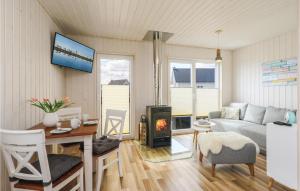 ein Wohnzimmer mit einem Sofa, einem Tisch und einem Kamin in der Unterkunft Beautiful Home In Ostseeresort Olpenitz in Olpenitz
