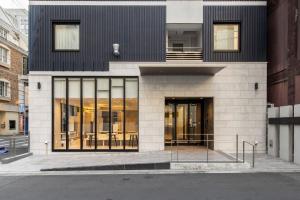 ein Gebäude mit Glastüren an einer Stadtstraße in der Unterkunft Fourz Hotel Kintetsu Osaka-Namba in Osaka