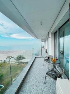 een balkon met een tafel en stoelen en de oceaan bij Sea On Mamaia in Mamaia