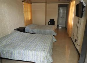 2 camas en una habitación de hotel con TV en Hostal San Ramon en Santa Rosa de Cabal