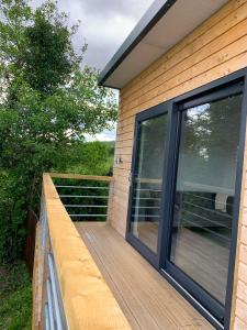 a wooden deck with glass doors on a house at Swan Cabin in Swanlinbar