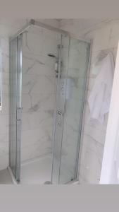 a shower with a glass door in a bathroom at Swan Cabin in Swanlinbar