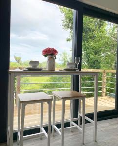 a table and two stools in front of a window at Swan Cabin in Swanlinbar