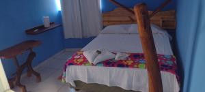 a bedroom with a bed with a wooden frame at pousada shalon e host holly land in Santo Amaro