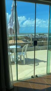 a patio with a table and a chair and an umbrella at Infinity Pousada in Aracaju