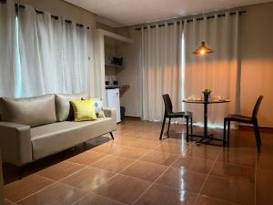 uma sala de estar com um sofá e uma mesa em Infinity Pousada em Aracaju