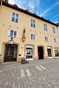 a large yellow building with white windows and doors at Villa Einhorn: Ruhe Oase mitten im Zentrum in Goslar