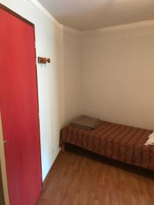 una camera con un letto e una porta rossa di T2 bis duplex 6 couchages situé aux BOTTIERES a Saint-Pancrace