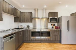 ニューキーにあるSea View, Newquay Spacious houseのキッチン(木製キャビネット、ステンレス製の電化製品付)