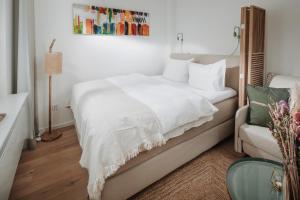 - une chambre avec un lit blanc et une chaise dans l'établissement Villa Fresena Bude 8, à Norderney