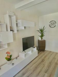 sala de estar con muebles blancos y TV de pantalla plana en Ferienwohnung Appartamento Da Vinci, en Eisenach