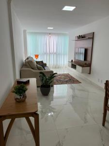 ein Wohnzimmer mit einem Sofa und einem Tisch in der Unterkunft Apartamento Encantador Centro Santa Teresa in Santa Teresa