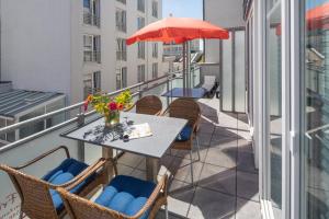 einen Balkon mit einem Tisch, Stühlen und einem Sonnenschirm in der Unterkunft Residenz Windjammer Residenz Windjammer Wohnung 2 in Norderney