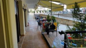 a balcony with tables and chairs and an umbrella at Hotel Makednos in Nikiti