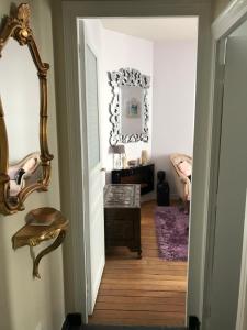 a hallway with a mirror and a wooden floor at Superbe appartement proche de la butte Montmartre in Paris