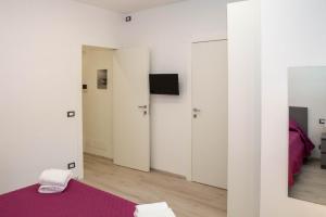 una camera con pareti bianche e un tappeto viola di Endless Summer Apartment a Marina di Ragusa