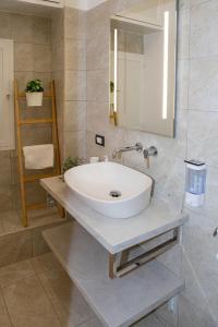 bagno con lavandino bianco e specchio di Endless Summer Apartment a Marina di Ragusa