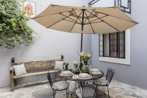 a table with chairs and an umbrella on a patio at Casa Recreo King Suite Apartments in Centro, San Miguel de Allende in San Miguel de Allende +51 photos